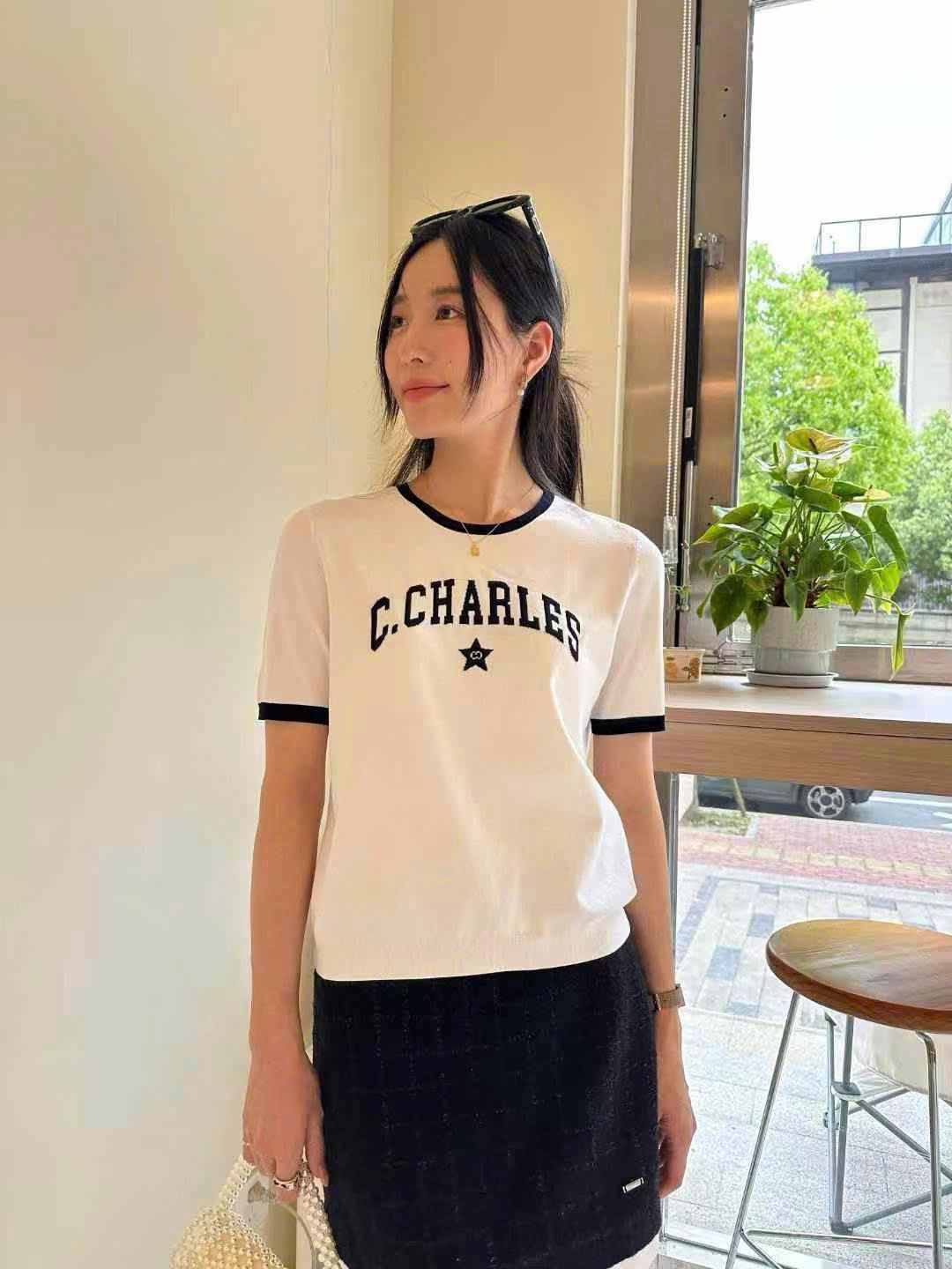 Áo trắng viền cổ, tay đen chữ C. Charles ngực sao