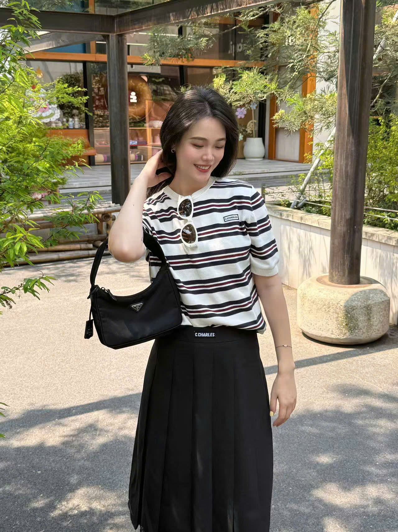 Chân váy dài xếp ly đen, cạp logo chữ trắng