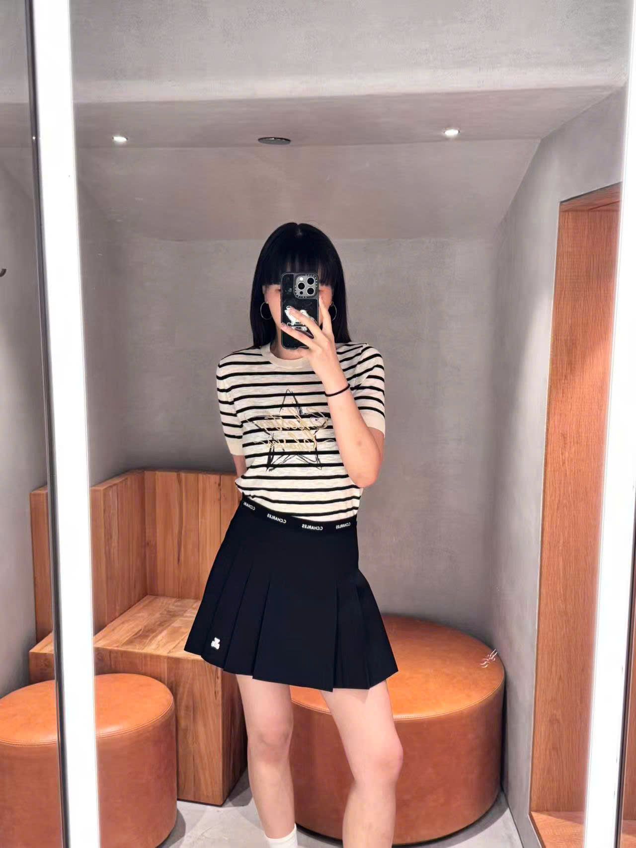 Chân váy ngắn xếp ly đen, gấu trắng, cạp chữ chạy