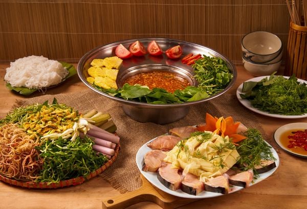 lẩu cá tầm măng chua nóng hổi trên bàn ăn