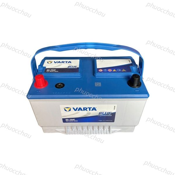 Bình ắc quy VARTA 65-7MF 12V 85Ah góc nhìn chéo từ trên xuống, nắp xanh có tay xách, cọc đỏ đen và tem CLARIOS