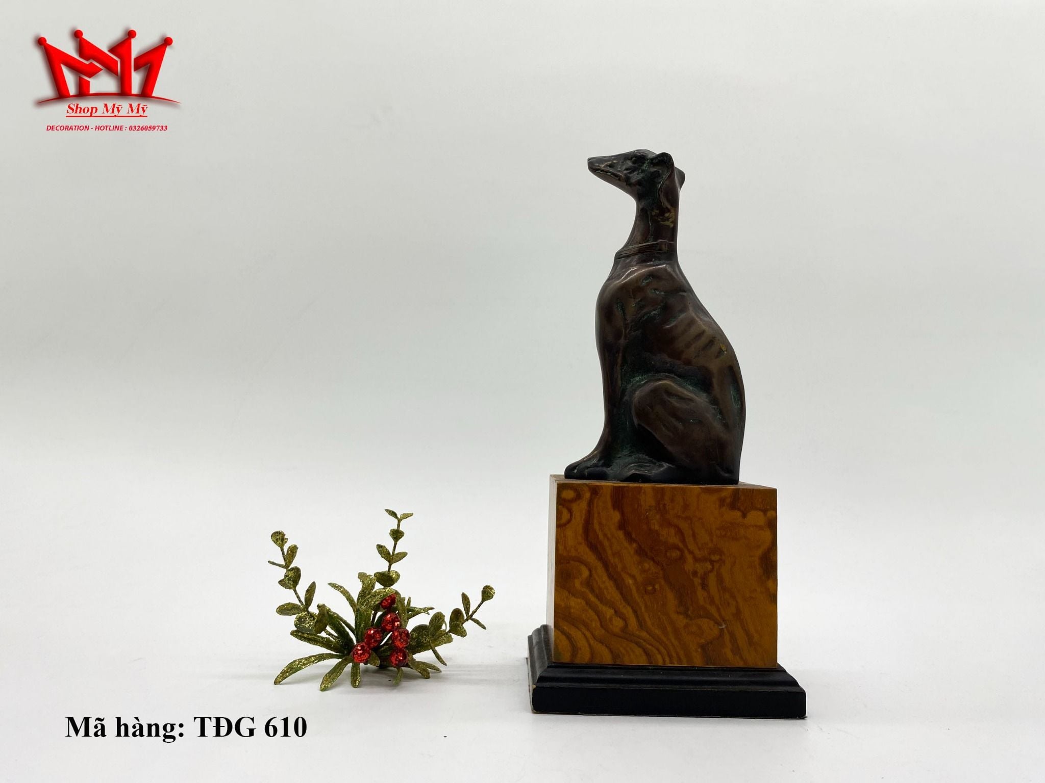 Tượng con chó ngồi trên đế gỗ được làm bằng đồng.