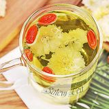 Hình ảnh một ly trà hoa cúc trắng với vài quả kỷ tử màu đỏ, tạo nên sự kết hợp bắt mắt và tươi mát.