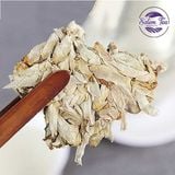 Miếng Trà Phổ Nhĩ Bạch Trà Xuân được tách ra bằng dụng cụ gỗ