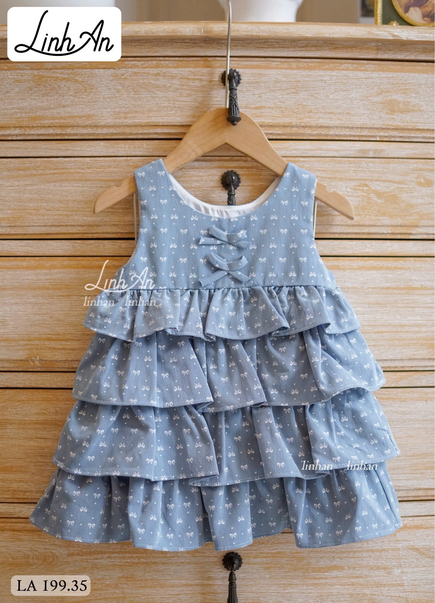 LA 199 - Váy jean giấy Linh An màu xanh nhạt họa tiết nơ bé gái size 90-160