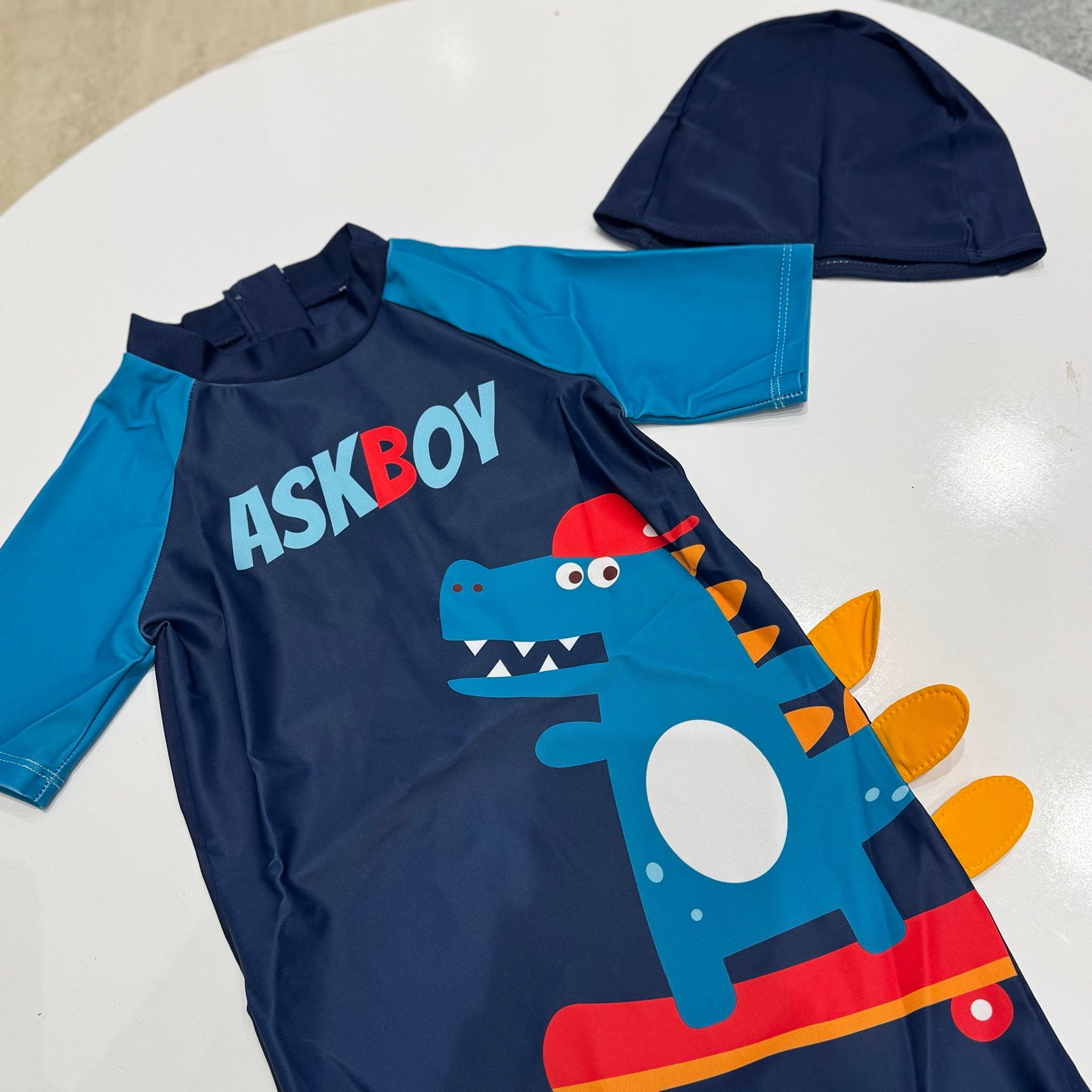 Bộ bơi Junior liền thân kèm mũ màu navy họa tiết khủng long bé trai size 110-160