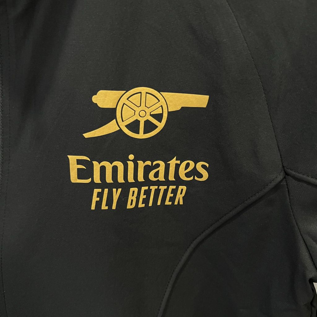 ÁO KHOÁC GIÓ ARSENAL ĐEN SỌC VÀNG DÀI 2022-2023