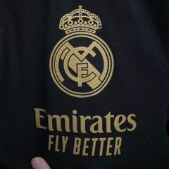 ÁO KHOÁC GIÓ REAL MADRID ĐEN SỌC VÀNG DÀI 2023/24