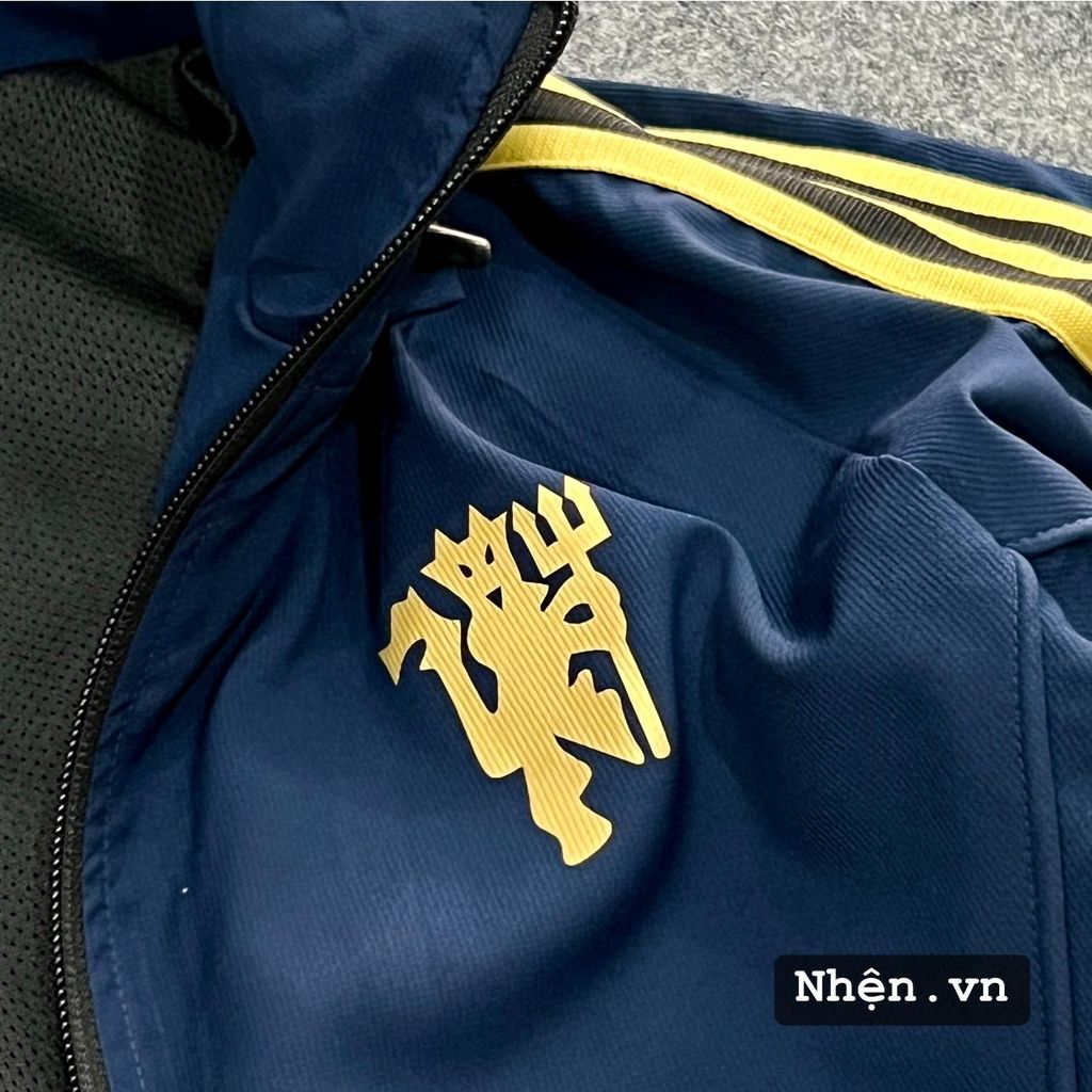 ÁO KHOÁC GIÓ MANCHESTER UNITED XANH ĐEN SỌC VÀNG DÀI 2022-2023