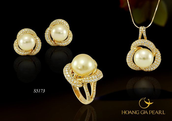 Lấy ý nghĩa từ biểu tượng bông hồng cài áo, thiết kế cách điệu hóa cánh hồng vàng ôm ấp ánh ngọc trai South Sea vàng kim phú quý tỏa nét đẹp tâm hồn thanh cao.