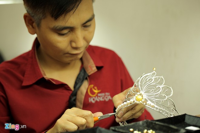 nguoi tho can than dinh tung vien ngoc trai. day la cong doan quan trong nhat vi moi vien co hinh dang khac nhau, moi vi tri lai can nhung vien ngoc co kich thuoc, hinh dang khac nhau de tao len su hai hoa, hoan hao cho vuong mien.