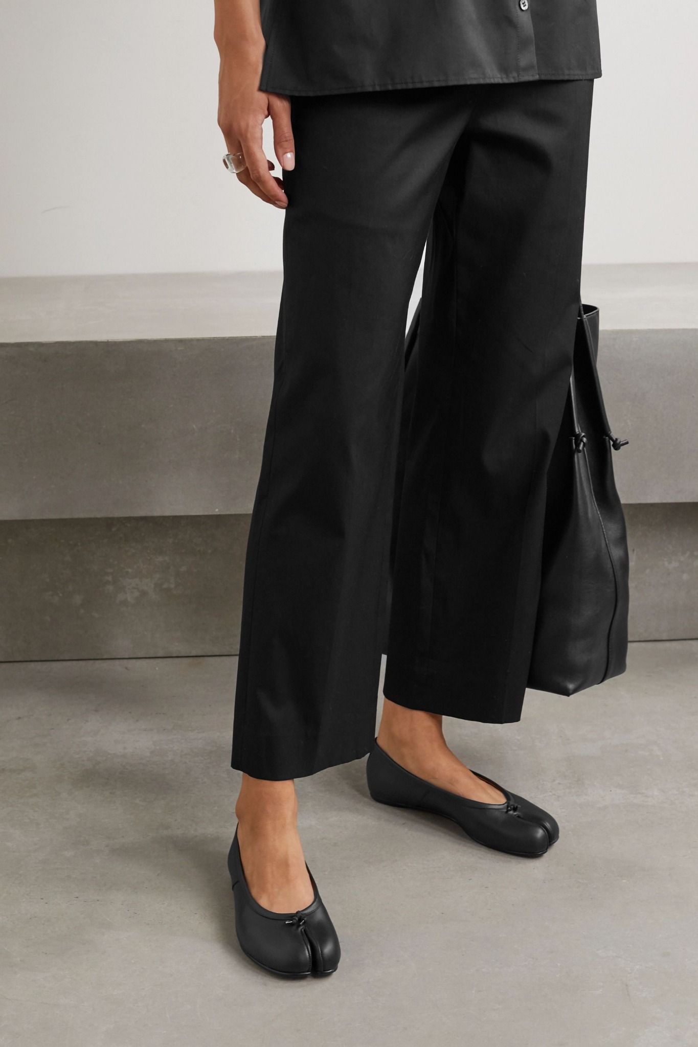 Model wearing black Maison Margiela Tabi ballerina flats with wide trousers