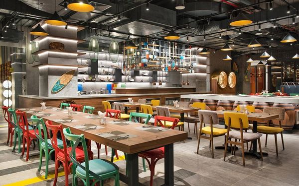 nhà hàng với quầy buffet và bàn ghế nhiều màu sắc
