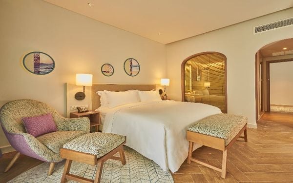 Căn phòng có đèn vàng, có ghế dựa và giường tại khách sạn mercure Vũng Tàu