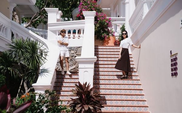 cầu thang tay vịn màu trắng 2 người đứng chụp hình