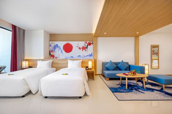 phòng ngủ có 1 giường đôi lớn, đèn ngủ, tivi và sofa