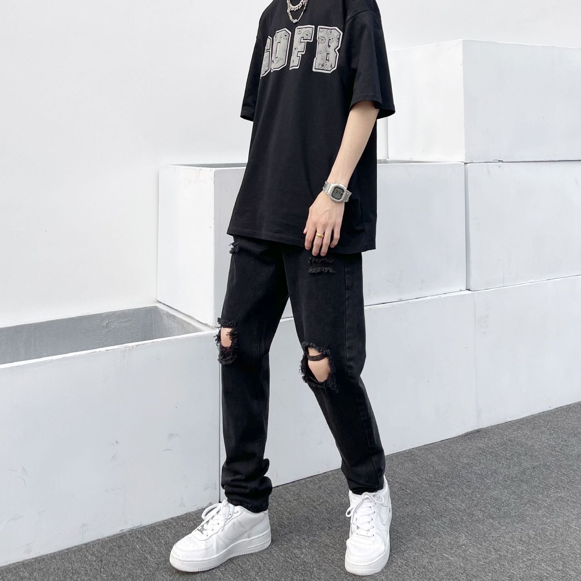 Black relaxed jeans with ripped knees and faded denim