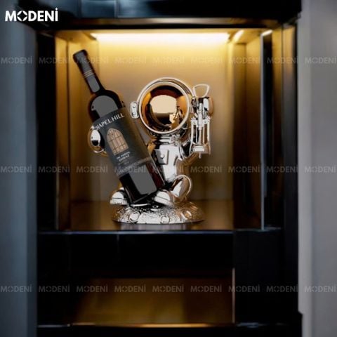 Tượng phi hành gia kê rượu Mable trong kệ tủ trang trí hiện đại.