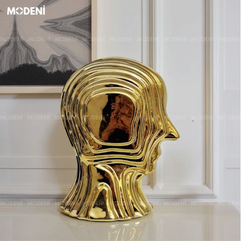 Decor tượng Vantis Gold đặt trên bàn đầu giường – nổi bật trong ánh đèn vàng ấm áp.