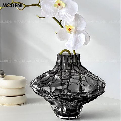 Bình hoa thủy tinh Moss đặt trên bàn trắng, phối lan trắng tinh tế – phong cách hiện đại nghệ thuật.