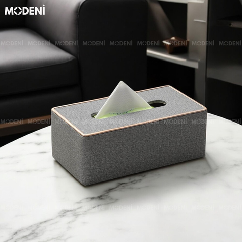 Hộp khăn giấy Modeni Xám Tro vải lanh cao cấp phối viền vàng hồng sang trọng đặt trên bàn làm việc.