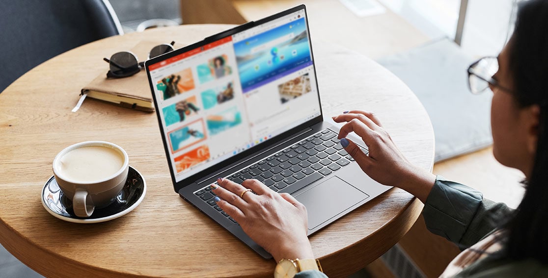 Person working on Yoga Slim 6i Gen 8 laptop at table with coffee next to them