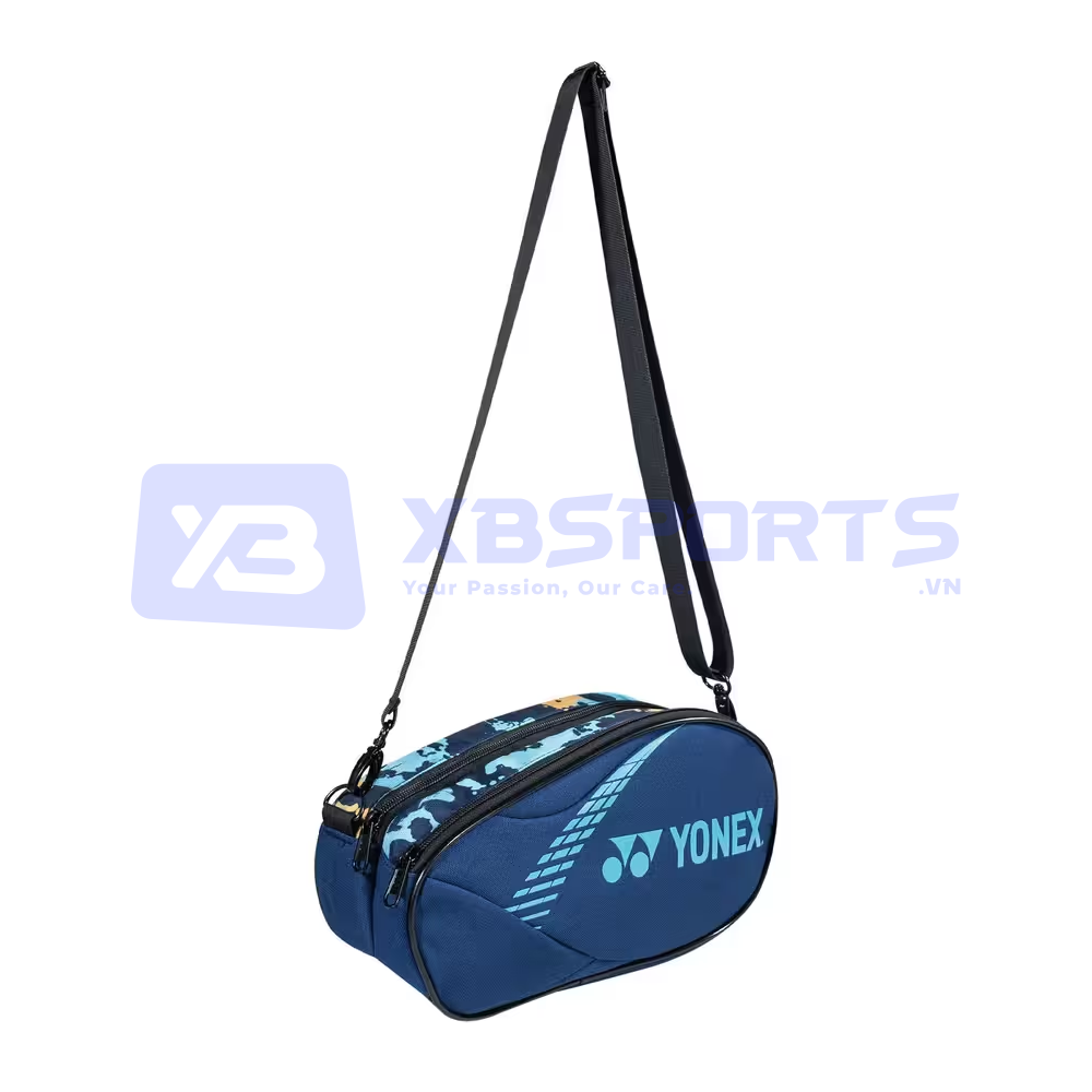 Túi mini Yonex BAG224B0139Z màu Blue, túi đeo chéo dáng oval thân xanh navy có đường chần nổi tạo vân, in chữ YONEX và logo YY cỡ lớn màu xanh nhạt ở mặt trước, phần khóa kéo trên có họa tiết loang xanh, dây đeo bản dẹt màu đen