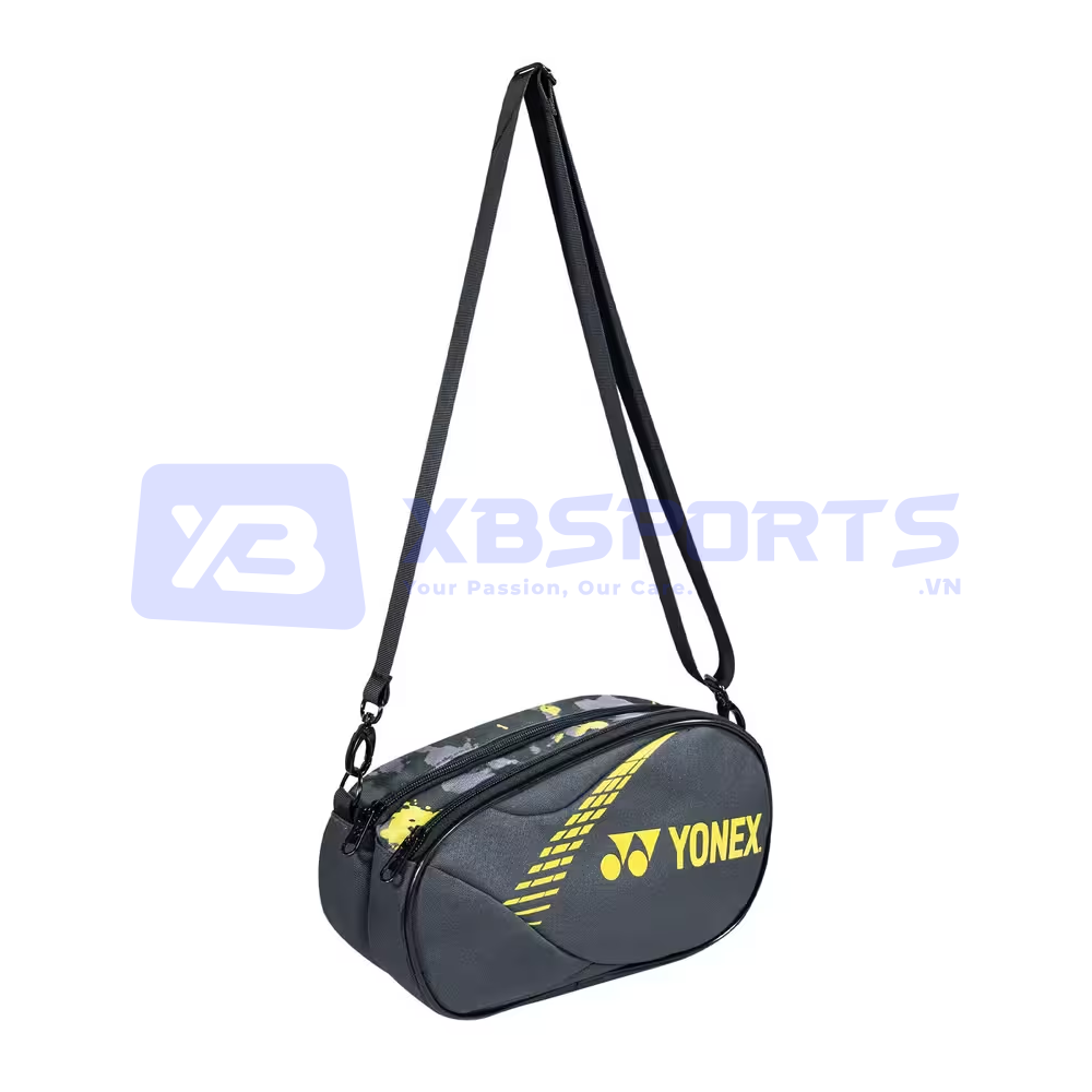 Túi mini Yonex BAG224B0139Z màu Dark Flower Grey Yellow, túi đeo chéo dáng oval thân xám đen có đường chần nổi, in chữ YONEX và logo YY cỡ lớn màu vàng chanh ở mặt trước, khóa kéo màu vàng, dây đeo màu đen