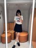  Chân váy ngắn xếp ly đen, gấu trắng, cạp chữ chạy 